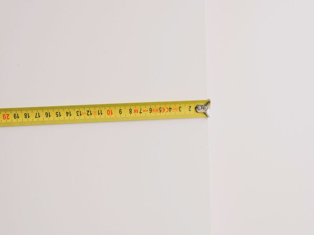 안마의자 문 폭 재기 - 흰 벽에 펼쳐 댄 노란 줄자 안마의자 문 폭 재기 - 흰 벽에 펼쳐 댄 노란 줄자